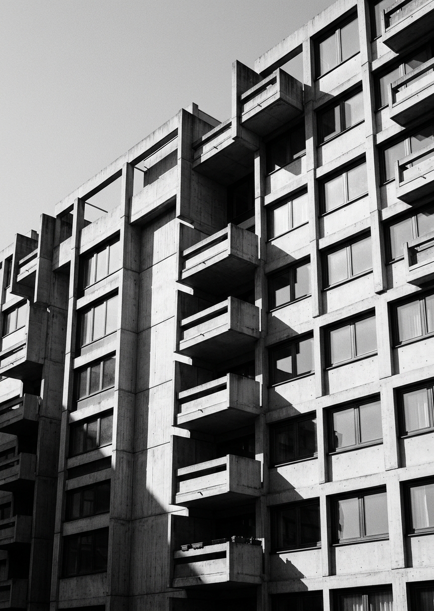 Stående svartvitt fotografi av minimalistisk Bauhaus-arkitektur med geometriska linjer, skarpa vinklar och dramatiska skuggor.