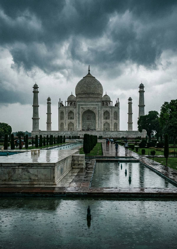 Hyperrealistisk bild av Taj Mahal insvept i monsunregn, med vattendroppar på marmorn och mörka, dramatiska moln som reflekteras i våta ytor.