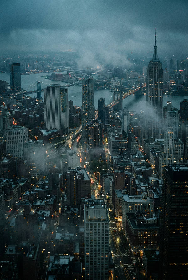 Vertikal bild av New York Citys stadssilhuett med höga skyskrapor och gråtoner i skymningen.