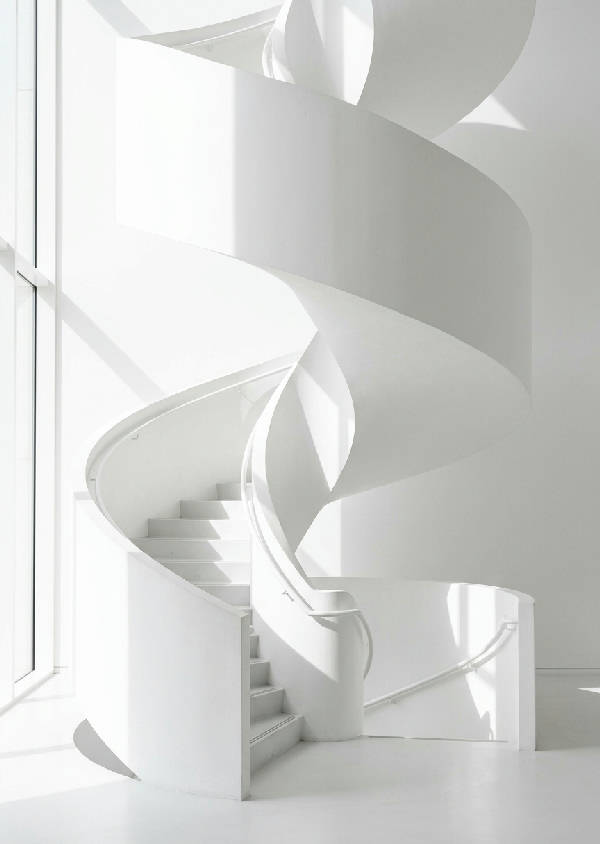 En vit, minimalistisk spiraltrappa som elegant vrider sig uppåt, badad i mjukt, drömskt ljus som skapar vackra skuggor.