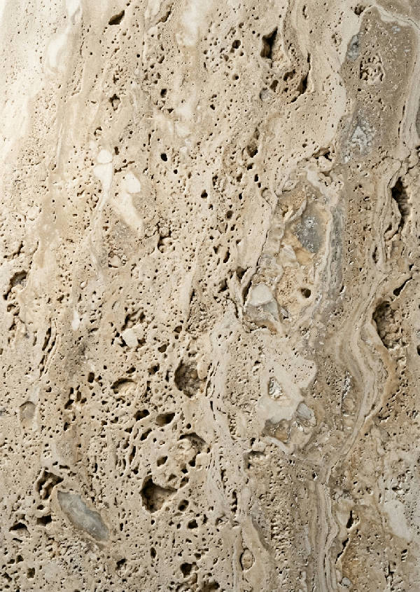 Närbild av naturlig travertinsten som visar dess detaljerade och ojämna ytstruktur i bruna nyanser