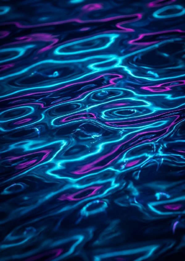 Makrofotografi av mörka vattenvågor på natten som lyser upp av elektriskt blått och cyan bioluminiscent plankton.