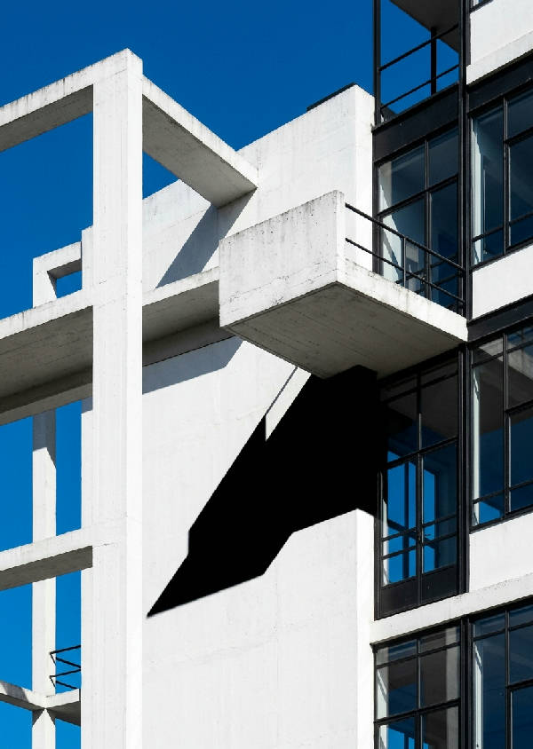 Närbild av en byggnad i Bauhaus-stil med geometriska former och rena linjer i grått och vitt.