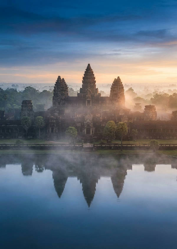 Hyperrealistiskt fotografi av Angkor Wat under blå timmen med vit dimma över vallgraven och reflektioner i vattnet.