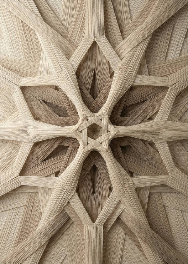 Närbild av ett tätt vävt, geometriskt fraktalmönster i porträttorientering med en central punkt som expanderar utåt. Nyanser av beige, från ljust linne till djupt beige.  Fokuserar på sammanlänkade former och subtila tonförändringar som definierar den intrikata strukturen.